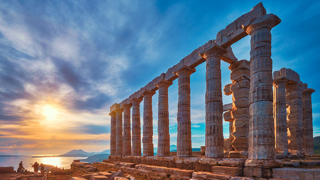 The temple of Poseidon in Sounion with a magnificent sunset behind it.
