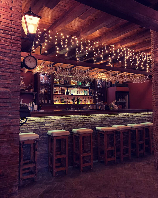The bar and a wall with a variety of wines and spirits.